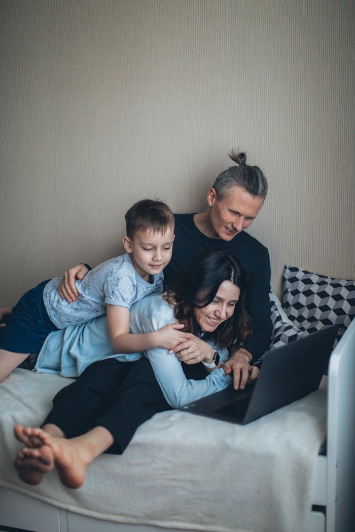 home-hero A family enjoying quality time together while using a laptop in their bedroom.