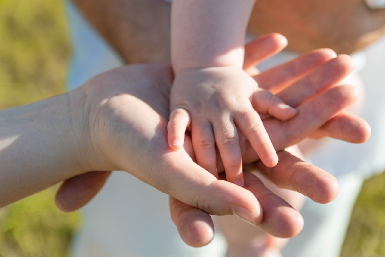 services-06 Close-up of parent and child's hands symbolizing love and connection.