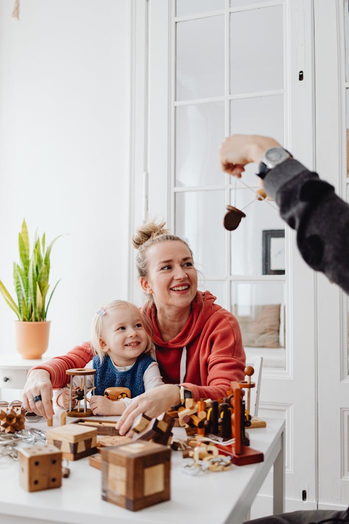A joyful interaction between a mother and child playing with wooden toys at a table.